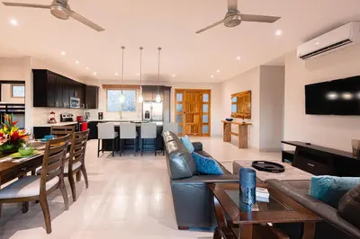 a living room and kitchen with a couch and a table at Casa De Los Sueños, Brand New Ocean View Home On 125 Acres! in Brasilito