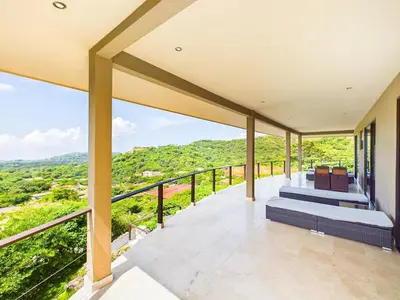 a balcony with a view of the mountains at Dos Rios #70- 6 Bedroom Home On 12 Acre in Brasilito