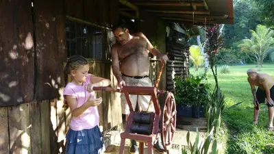 a man and a little girl playing with a wooden chair at Eco Lodge&Farm Rustic Roots Reserve in Drake