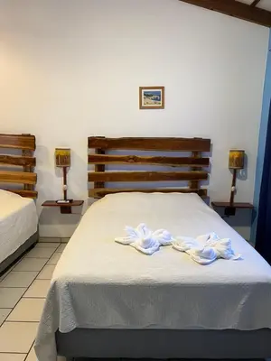 a bedroom with two beds and two lamps at Cabinas El Colibri, Apart Hotel in Carrillo