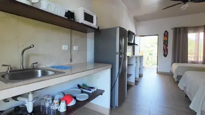 a kitchen with a sink and a counter top at Cabinas El Colibri, Apart Hotel in Carrillo