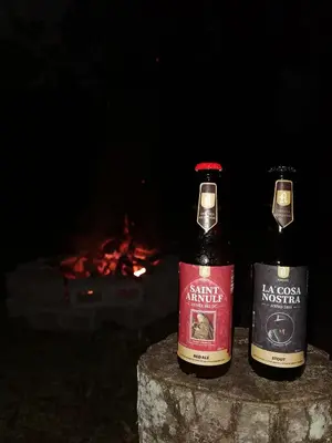 two bottles of wine sitting on a stone block with a fire at The Chocolate Lodge in Jiménez
