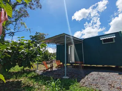 a green tiny house with a roof at The Chocolate Lodge in Jiménez