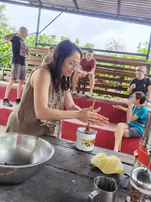 a woman standing at a table preparing food with people at The Chocolate Lodge in Jiménez