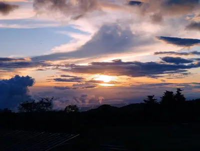 a sunset with the sun setting in the sky at Siary Aparment 2 in Monteverde Costa Rica