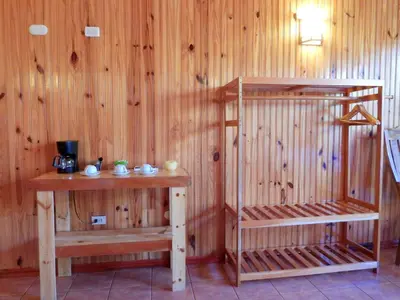 a room with a wooden wall with a shelf and a table at Miztli Lodge & Adventure in Monteverde Costa Rica