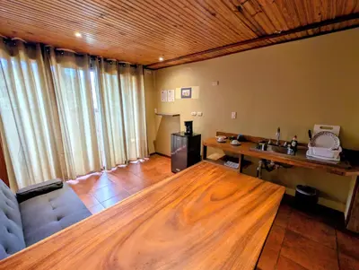 a living room with a large wooden table at Miztli Lodge & Adventure in Monteverde Costa Rica