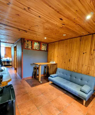 a blue couch in a room with a wooden ceiling at Miztli Lodge & Adventure in Monteverde Costa Rica