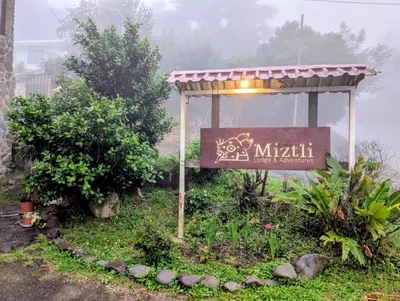 a sign for a mithil sign in a garden at Miztli Lodge & Adventure in Monteverde Costa Rica