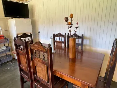 a wooden table with chairs and a vase with flowers on it at Large & Confortable Family House in Fortuna