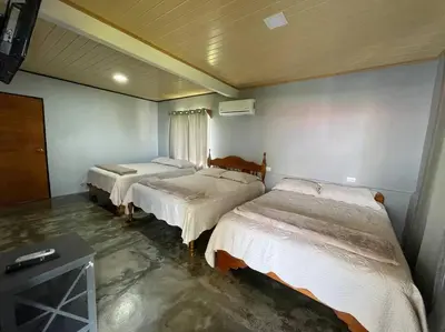 a room with three beds and a television in it at Large & Confortable Family House in Fortuna