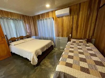 a bedroom with two beds and wooden walls at Large & Confortable Family House in Fortuna
