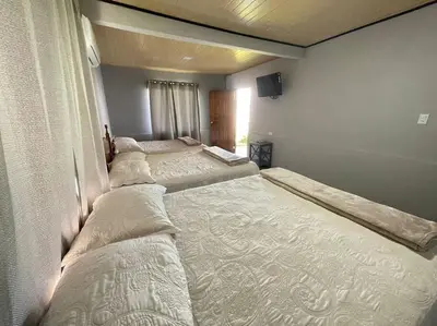 two beds in a room with a tv on the wall at Large & Confortable Family House in Fortuna