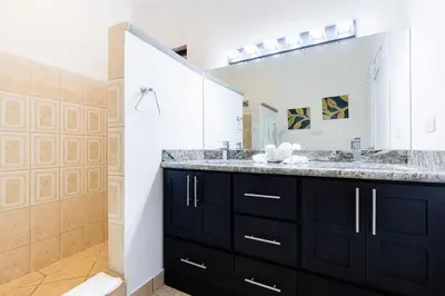 a bathroom with two sinks and a large mirror at Sunrise 27- 2 Bedroom Ocean View Condo in Tamarindo