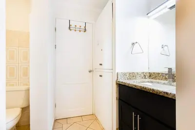 a bathroom with a sink and a toilet and a mirror at Sunrise 27- 2 Bedroom Ocean View Condo in Tamarindo