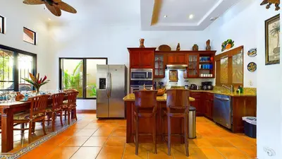 a kitchen with a table and chairs and a refrigerator at Jade Coast #2 in Tamarindo