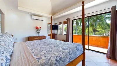 a bedroom with a bed and a large window at Jade Coast #2 in Tamarindo