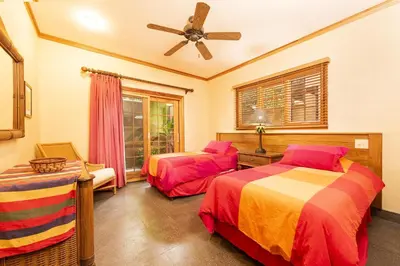 a bedroom with two beds and a ceiling fan at La Esquina 7 Langosta- 2 Bedroom Luxury Condo in Tamarindo