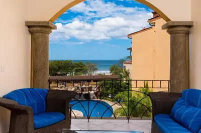 a balcony with chairs and a view of the ocean at Sunrise 23- 2 Bedroom Ocean View Condo in Tamarindo