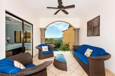 a living room with a blue couch and chairs at Sunrise 23- 2 Bedroom Ocean View Condo in Tamarindo