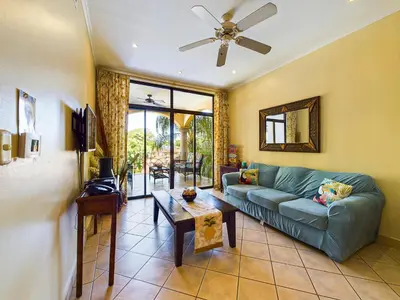 a living room with a couch and a table at Sunrise 38- Ocean View 2 Br Condo, Steps To The Beach in Tamarindo