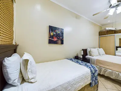 a bedroom with two beds and a ceiling fan at Sunrise 38- Ocean View 2 Br Condo, Steps To The Beach in Tamarindo