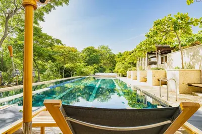 a swimming pool with a chair next to a house at Paseo Miraflores 8 At Las Catalinas in Tempate