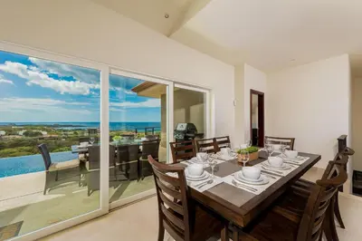 a dining room with a table and a view of the ocean at Casa De La Perla, Ocean View 4 Bedroom Home in Tamarindo