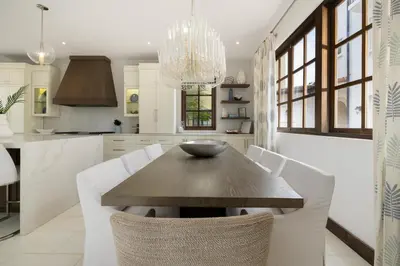 a kitchen with a wooden table and white chairs at Paseo Miraflores 7 At Las Catalinas in Tempate
