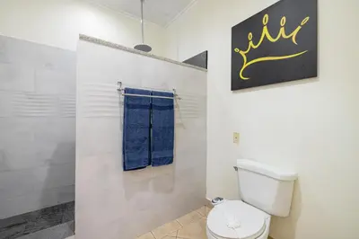 a bathroom with a toilet and a blue towel at Sunrise 6- Ocean View 2 Br Condo, Steps To The Beach in Tamarindo