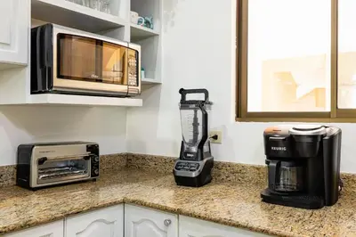 a kitchen counter with a blender and a microwave at Sunrise 6- Ocean View 2 Br Condo, Steps To The Beach in Tamarindo