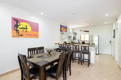 a dining room with a table and chairs and a kitchen at Sunrise 6- Ocean View 2 Br Condo, Steps To The Beach in Tamarindo