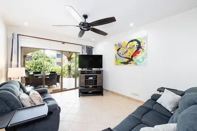 a living room with two couches and a flat screen tv at Sunrise 6- Ocean View 2 Br Condo, Steps To The Beach in Tamarindo