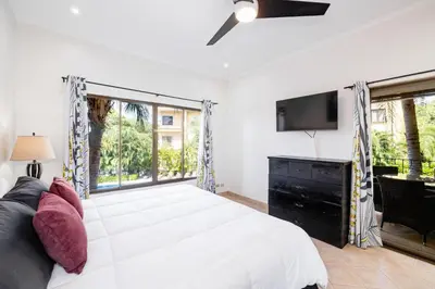 a bedroom with a large bed and a tv at Sunrise 6- Ocean View 2 Br Condo, Steps To The Beach in Tamarindo