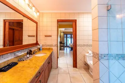 a bathroom with a sink and a mirror and a toilet at Jade Coast 3- Private 5 Bedroom Villa in Tamarindo