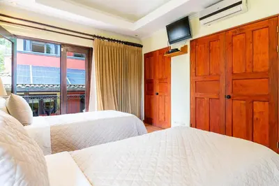 a bedroom with two beds and a window at Jade Coast 3- Private 5 Bedroom Villa in Tamarindo