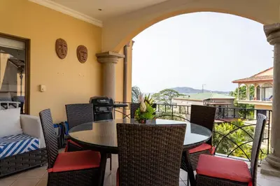 a patio with a table and chairs on a balcony at Sunrise 12- 2 Bedroom Penthouse in Tamarindo