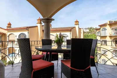 a patio with a table and chairs on a balcony at Sunrise 12- 2 Bedroom Penthouse in Tamarindo