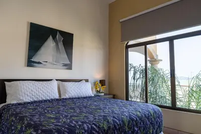 a bedroom with a bed with a sailboat painting on the wall at Sunrise 12- 2 Bedroom Penthouse in Tamarindo