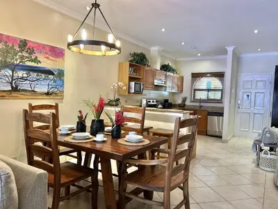 a kitchen and dining room with a wooden table and chairs at Sunrise 1- 3 Bedroom Poolside Condo in Tamarindo