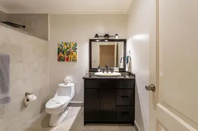 a bathroom with a sink and a toilet and a mirror at Sunrise 1- 3 Bedroom Poolside Condo in Tamarindo