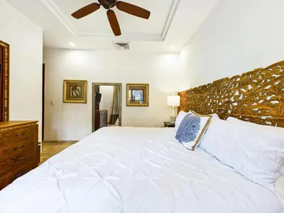 a bedroom with a large white bed with a ceiling fan at Matapalo 101- 3 Bedroom Poolside Luxury Condo At Tamarindo in Tamarindo