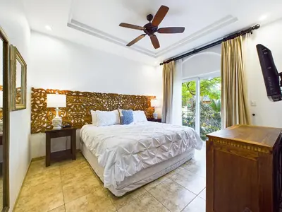 a bedroom with a bed and a ceiling fan at Matapalo 101- 3 Bedroom Poolside Luxury Condo At Tamarindo in Tamarindo