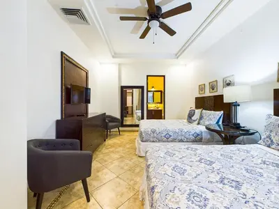 a hotel room with two beds and a ceiling fan at Matapalo 101- 3 Bedroom Poolside Luxury Condo At Tamarindo in Tamarindo