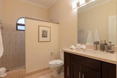 a bathroom with a toilet and a sink at Sunrise 48- 3 Bedroom Ocean View Penthouse Condo in Tamarindo