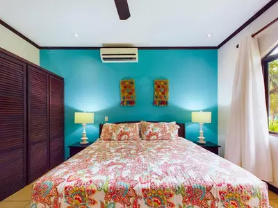 a bedroom with a bed and a blue wall at Catalina Cove 3- 6 Bedroomloft Home in Brasilito