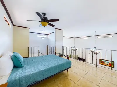 a bedroom with a bed with a ceiling fan at Catalina Cove 3- 6 Bedroomloft Home in Brasilito