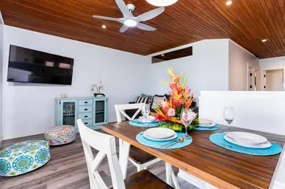 a dining room with a wooden table and chairs at Flamingo Marina Cove 404- Oceanfront Condo in Playa Flamingo