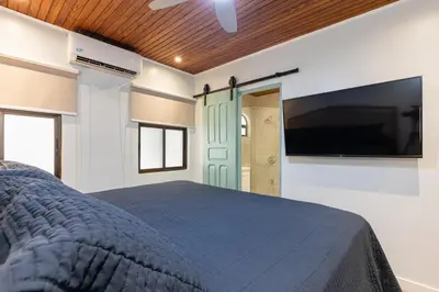 a bedroom with a bed and a flat screen tv at Flamingo Marina Cove 404- Oceanfront Condo in Playa Flamingo