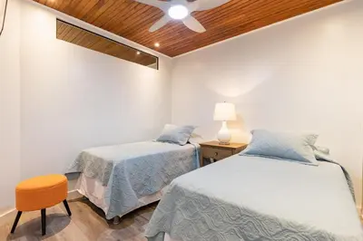 a bedroom with two beds and a ceiling fan at Flamingo Marina Cove 404- Oceanfront Condo in Playa Flamingo